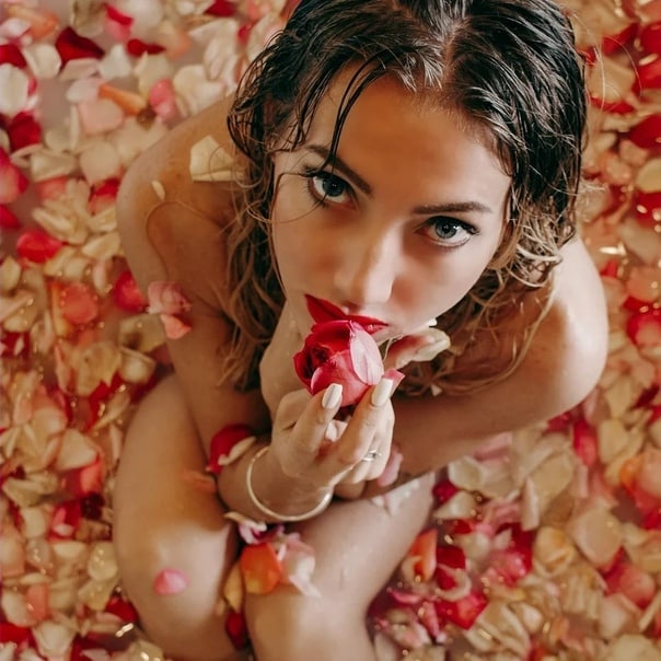 Голая девушка на кровати с лепестками роз