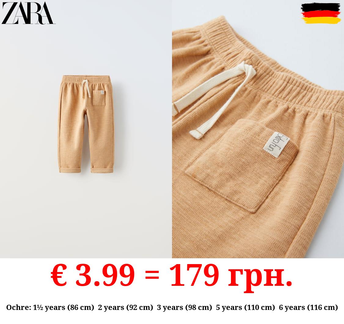 TEXTURED TROUSERS WITH LABEL