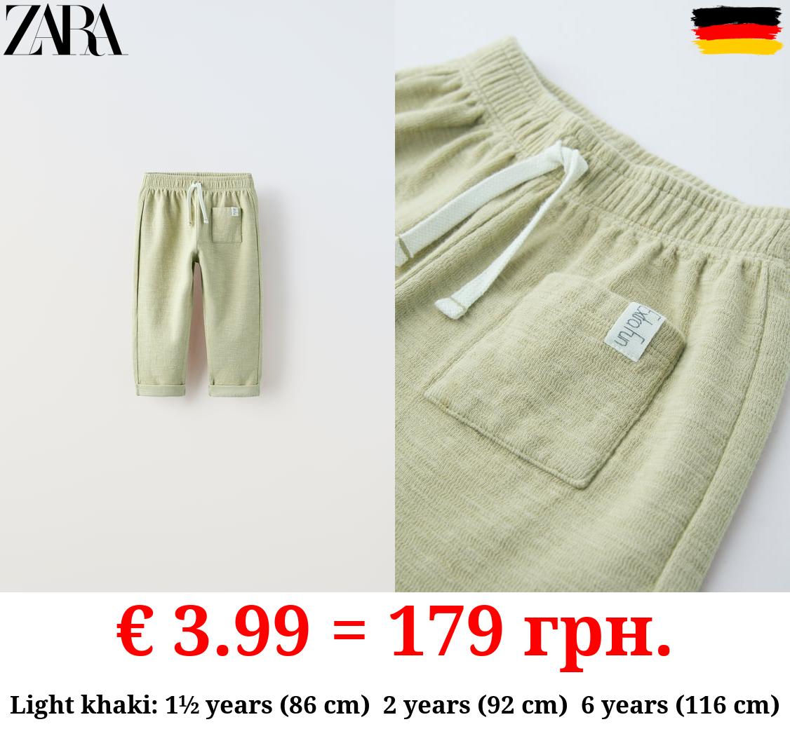 TEXTURED TROUSERS WITH LABEL