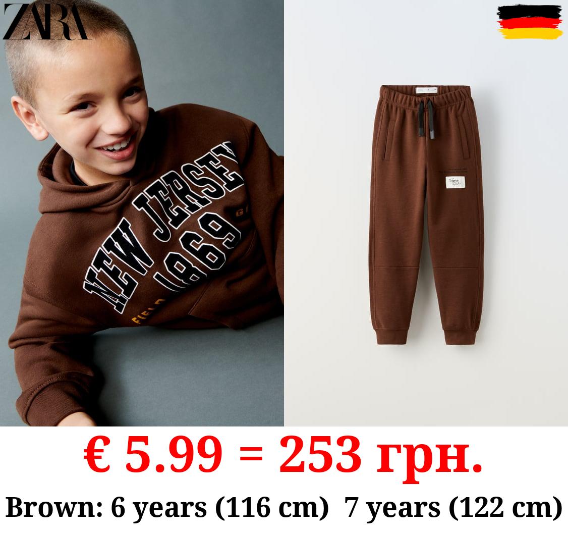 PLUSH TROUSERS WITH LABEL APPLIQUÉ