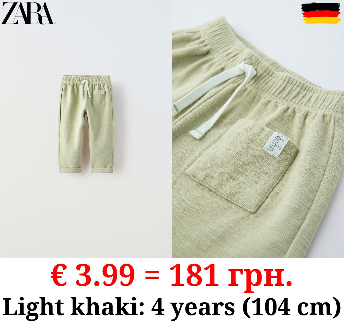 TEXTURED TROUSERS WITH LABEL