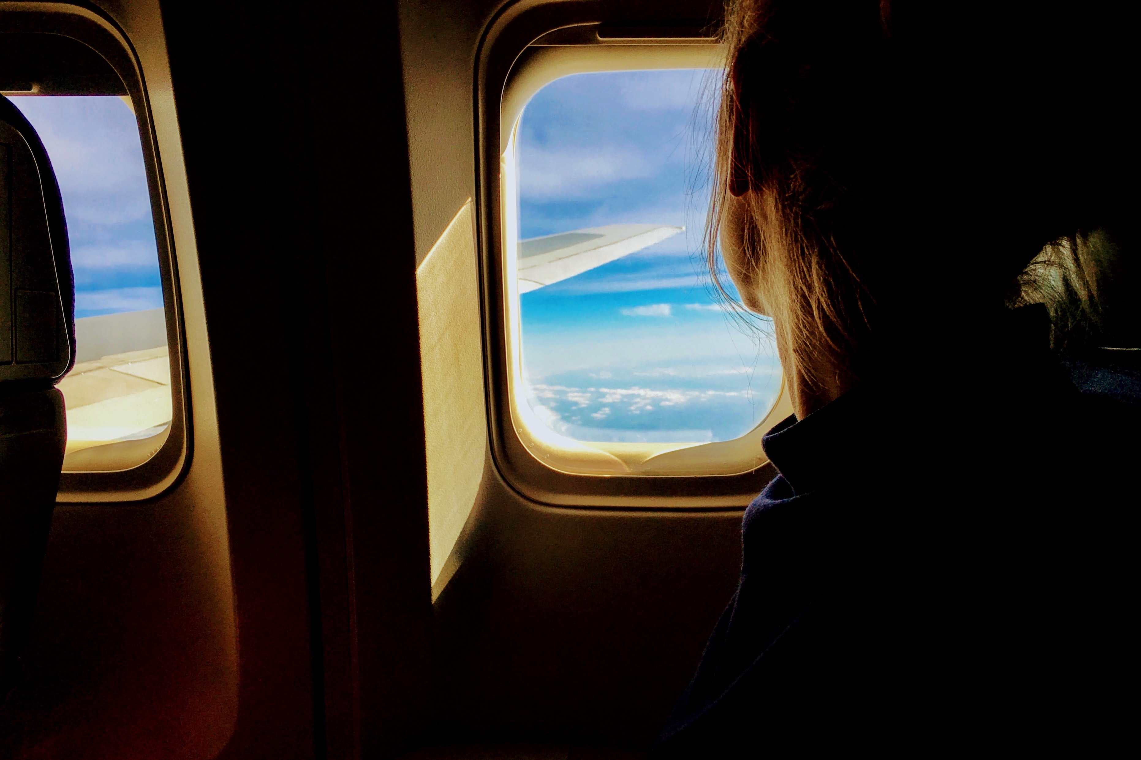 Телефон во время полета в самолете. Иллюминатор самолета. Окно самолета. Девушка в самолете. Девушка у иллюминатора самолета.