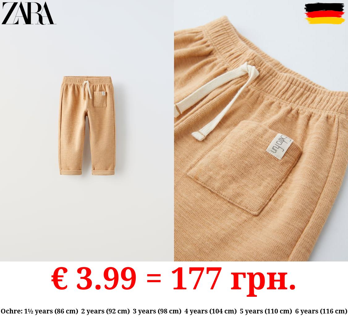 TEXTURED TROUSERS WITH LABEL