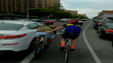Ciclista se agarra a su compañero y sale despedido