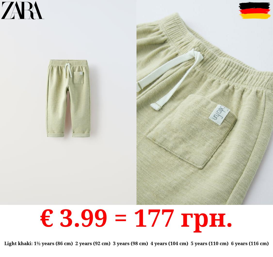 TEXTURED TROUSERS WITH LABEL