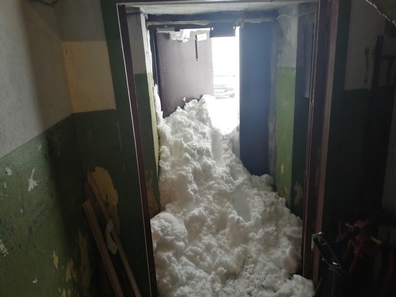 Сугробы на дверь. Завалило снегом двери в подъезд. Сугроб у подъезда. Снег у подъезда. Заснеженный подъезд.