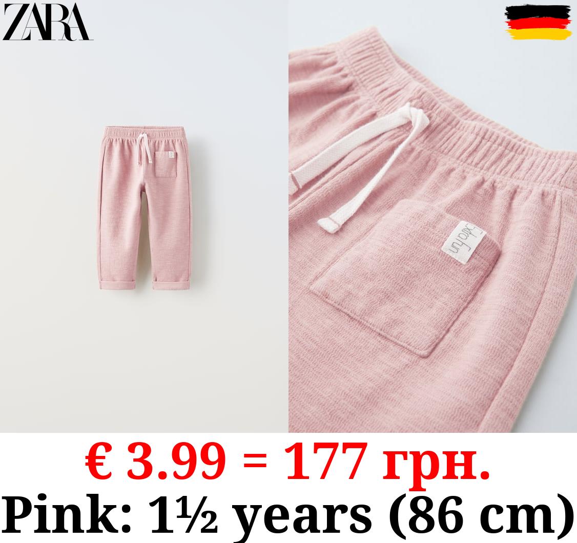 TEXTURED TROUSERS WITH LABEL