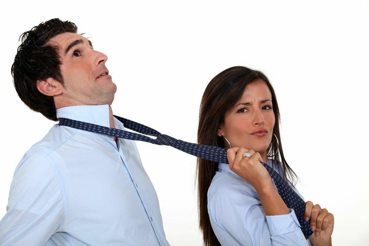 Девушка тянет мужчину за галстук