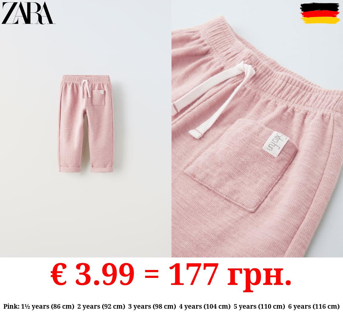 TEXTURED TROUSERS WITH LABEL