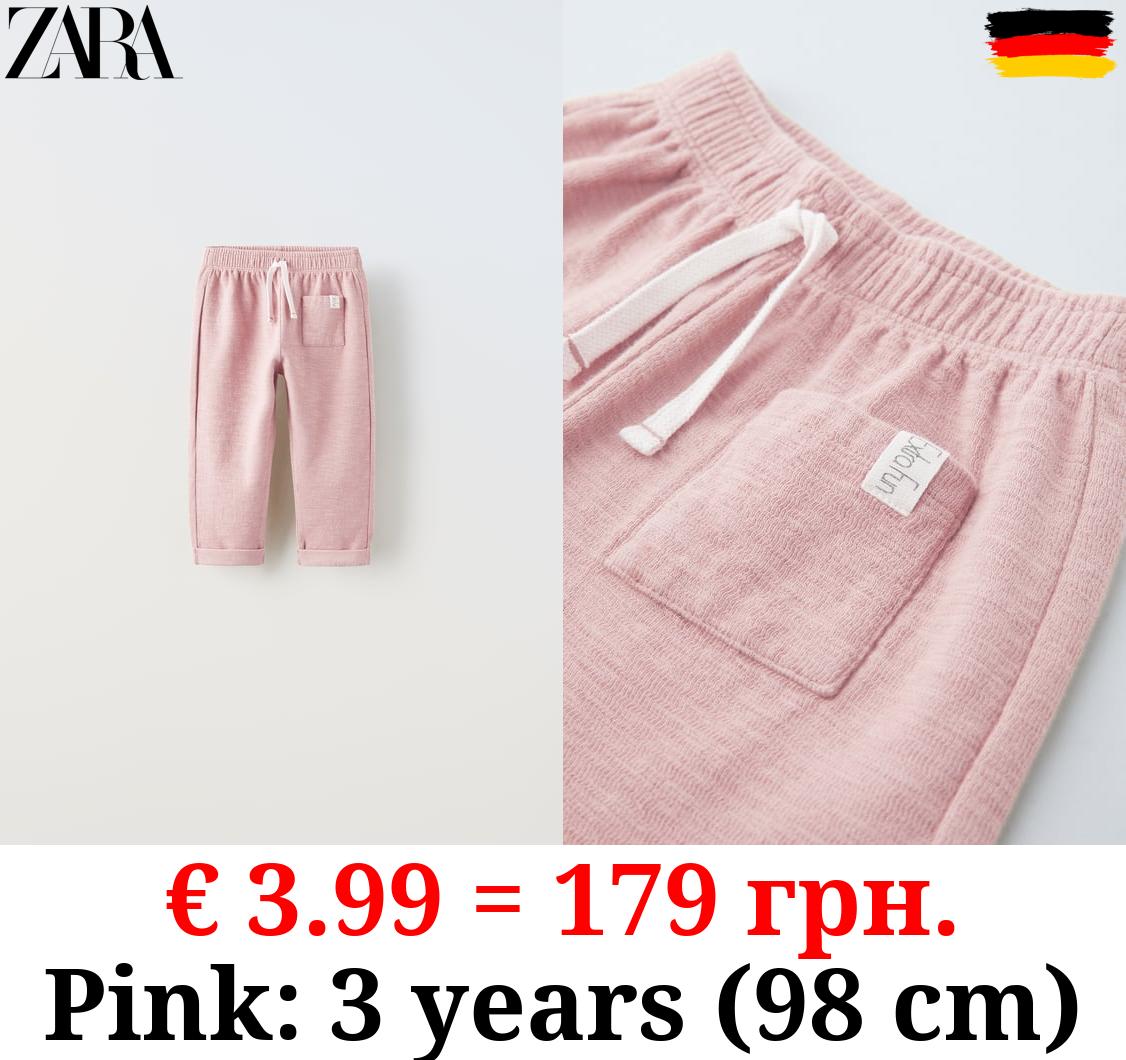 TEXTURED TROUSERS WITH LABEL